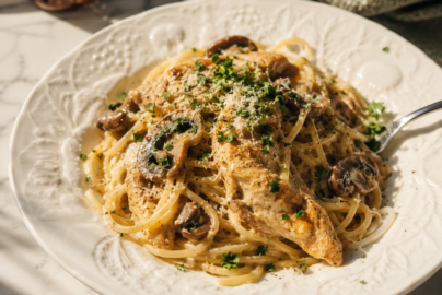 Creamy chicken spaghetti with mushrooms, pepper jack cheese, and imported Italian pasta served in a white bowl.